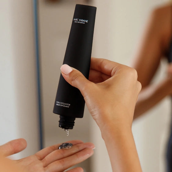 Marc Inbane Black Exfoliator ansiktspeeling pressas ut i hand, effektiv exfoliering med aktivt kol och återfuktande ingredienser.