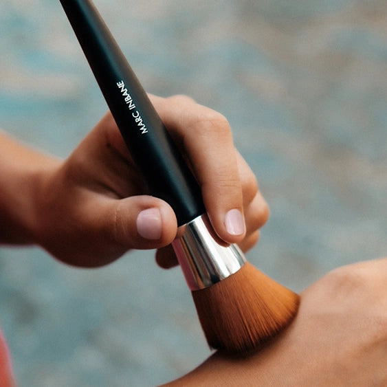 Marc Inbane Powder Brush testas på handen inför applicering på huden.