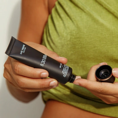 Person tar ut Marc Inbane Crème Solaire Bronze SPF30 solkräm på fingret för applicering.