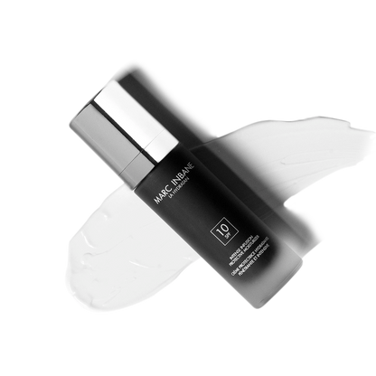 Marc Inbane La Hydratan SPF 10 fuktgivande dagkräm med silvrig pumpflaska liggande på vit bakgrund med krämtextur.